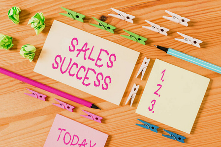 彩色衣夾放在木制地板中央的空矩形方形提醒紙條周圍。有凹槽和槽的木頭。辦公用品,鉛筆和鋼筆。